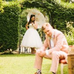 groom in peach coloured suit with bowtie, bride and groom wedding photo ideas,bride and groom retro garden wedding
