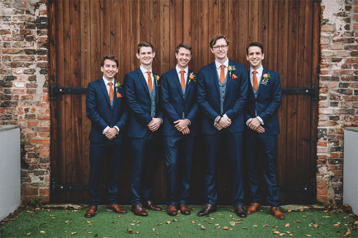 Autumn wedding - Groom and groomsmen in dark blue suit with orange ties