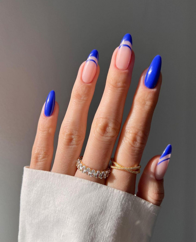 Female hand with long nails and light blue manicure with bottles of nail  polish Stock Photo - Alamy