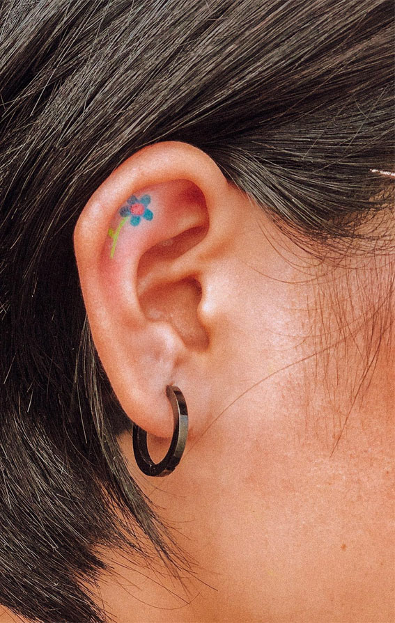 Tiny Treasures Meaningful Small Tattoo Inspirations : Tiny Blue Flower Inside Ear Tattoo