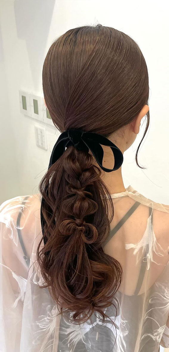 On-Trend Bow Hairstyles for a Chic and Playful Look : Messy Braid & Ponytail with Dark Blue Bow