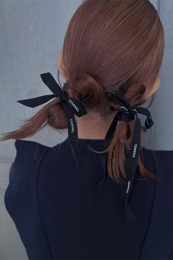 On-Trend Bow Hairstyles for a Chic and Playful Look : Messy Low Double Buns with Chanel Bows