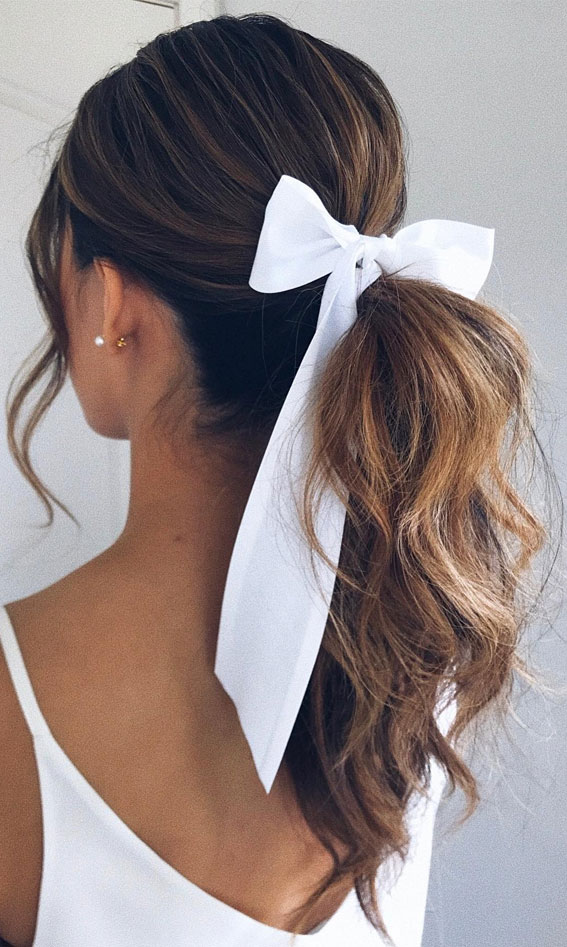 On-Trend Bow Hairstyles for a Chic and Playful Look : Textured Bridal Ponytail with White Bow
